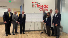 Steve Taylor Sr. presents a $1 million donation check to representatives of the Toledo Clinic Cancer Centers during the announcement of the Taylor Cancer Research Center in Maumee, Ohio, honoring the legacy of Julie Taylor and supporting local cancer research.