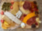 Charcuterie board with artisan cheeses, cured meats, crackers, fresh fruit, and olives