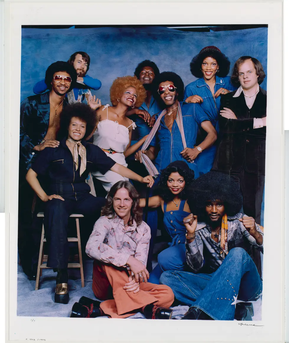 Herb Greene photograph of members of Sly and the Family Stone posing against a blue background