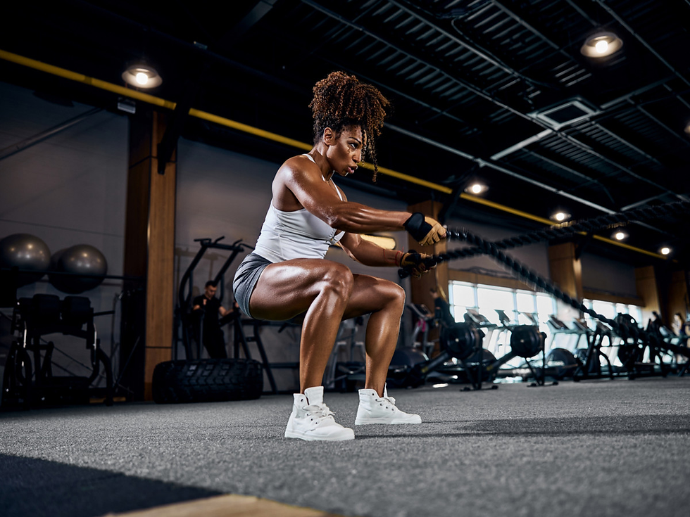 Athlete performing battle rope exercises in a gym to build strength, endurance, and burn fat through high-intensity training.