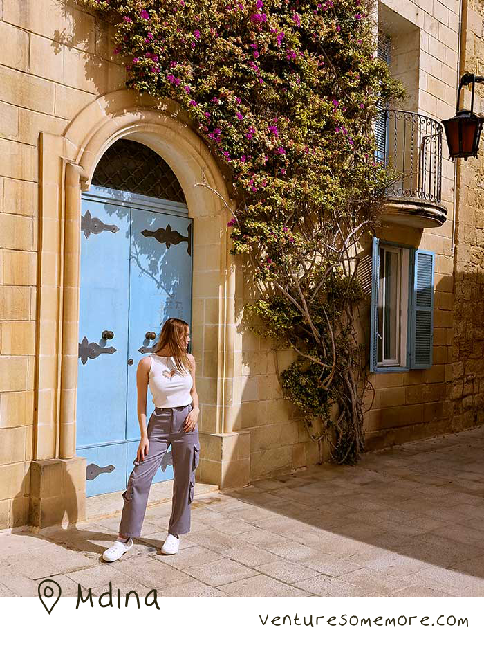 Mdina walled medieval city in Malta. Blue door and flowers growing up building