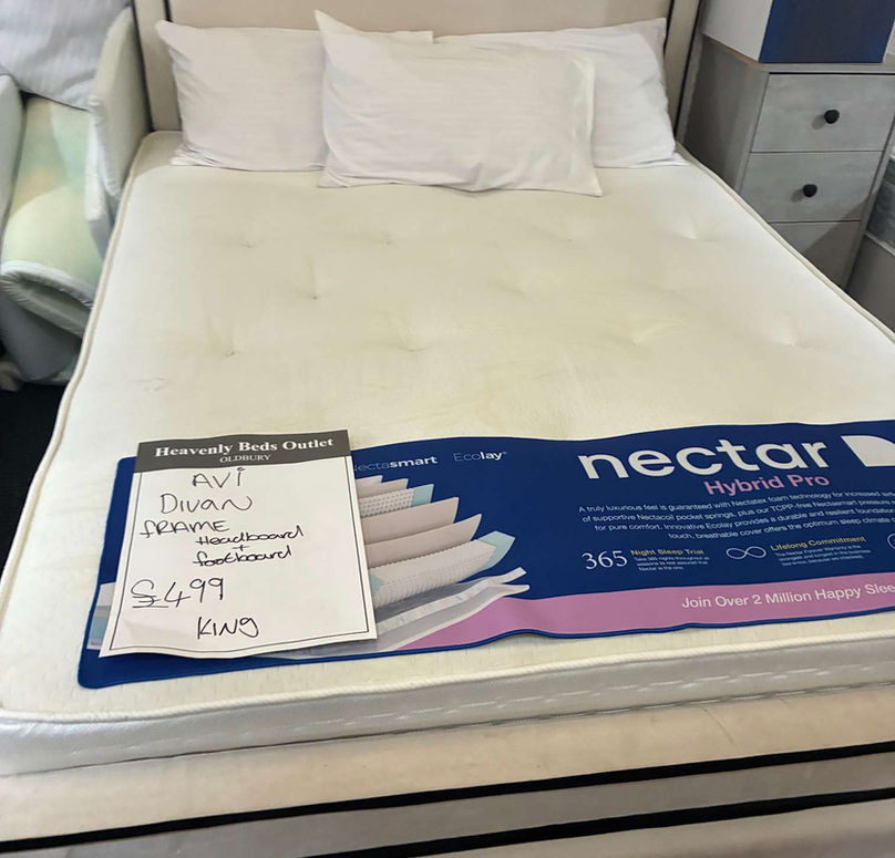 A neatly made queen-sized bed with a white mattress displayed in a store