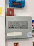 Wall-mounted fire alarm panel with colored buttons and indicators