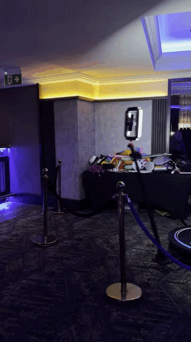 People celebrating and filming fun slow-motion clips on a 360 video booth at a party event.