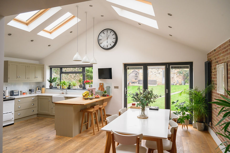 A modern kitchen and dining area with skylights and large glass doors
