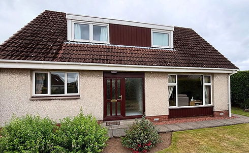 A cozy suburban house with a sloped roof and dormer windows