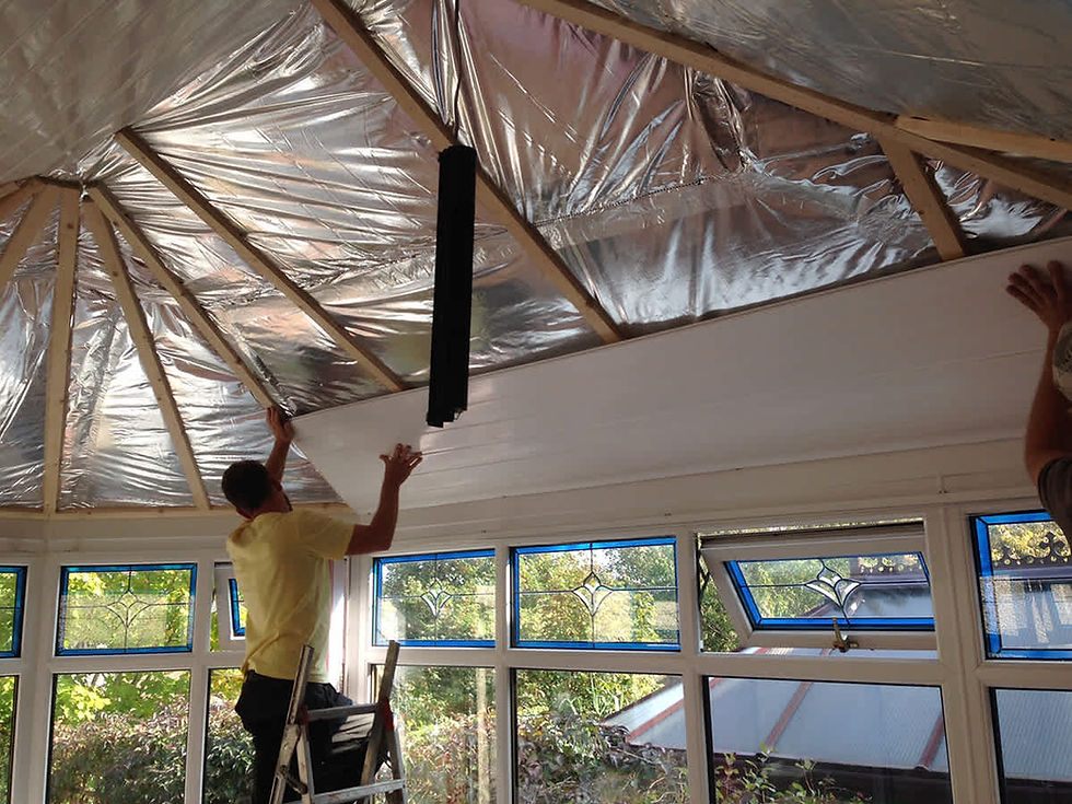 Tradesman installing timber framing for conservatory insulation