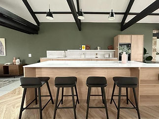 Modern kitchen with a white countertop island, four dark stools