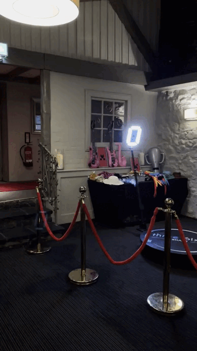 360 photo booth hire setup with LED lighting and guests posing on the rotating platform at a wedding reception.