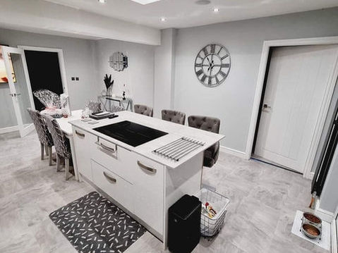 Modern kitchen with a central island, bar stools, and a skylight