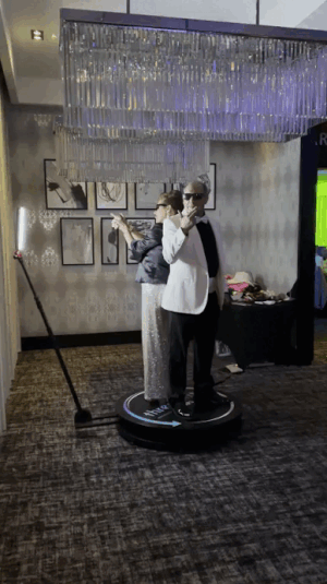 Branded 360 photo booth experience with guests creating shareable social media videos at an event.