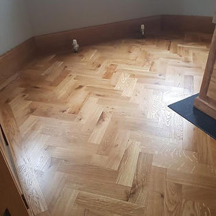 Traditional oak parquet flooring with herringbone pattern in a lounge