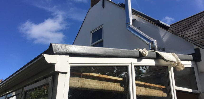 A white house with a sloped roof and a tall chimney