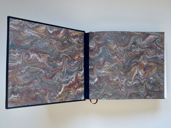 A full leather binding in a dark blue calf skin with hand-marbled end-papers and full edge gilt in 22 carat gold.