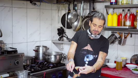 Chef Hazer Amani and founder Tarkan Uğur cooking together in the Kepos Balık Evi kitchen in Ankara.