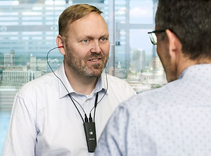 PErson wearing Widex Pro Link Connector with a hearing care professional fitting the hearing aids.