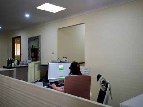 Dawn, our receptionist, working on her computer, likely making someone's appointment more comfortable, here at the Bruce Psychology clinic in Mandurah.