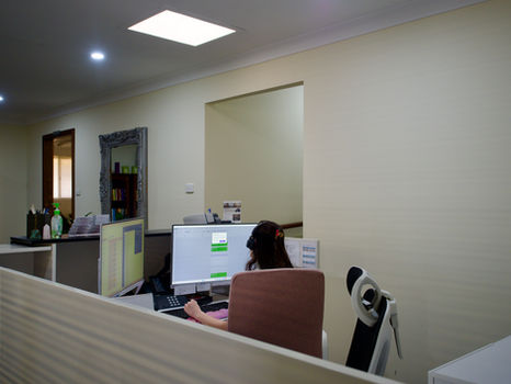 Dawn, our receptionist, working on her computer, likely making someone's appointment more comfortable, here at the Bruce Psychology clinic in Mandurah.