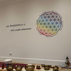 Yoga Studio Flower of Life. Die Wände sind mit beruhigenden Farben gestaltet, und das Dekor enthält Elemente des Flower-of-Life-Symbols, wie auch andere inspirierende Symbole des Yoga und der Spiritualität.
Eine sanfte Beleuchtung, sanfte Klänge der Klangschalen schaffen eine entspannende Atmosphäre.