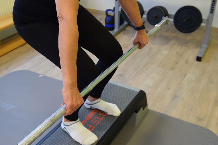 Close-Up einer Übung mit Hantelstange von Physiotherapeutin Media Topic, Physiotherapie Ternitz