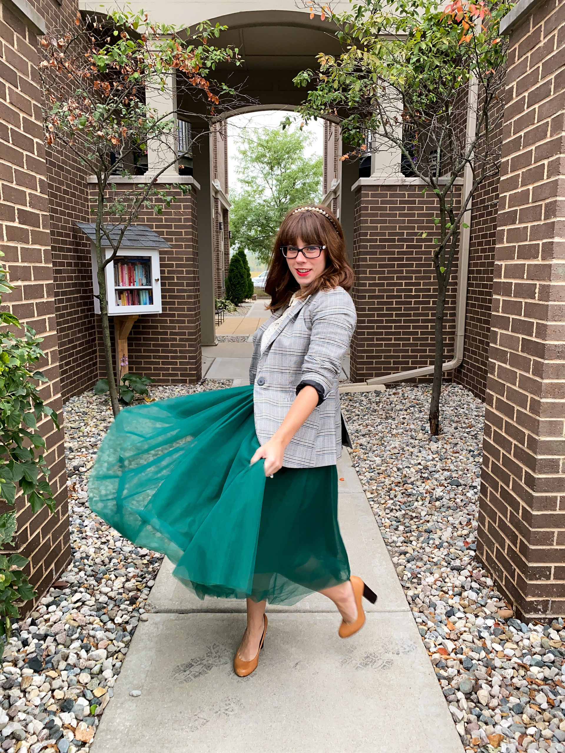 Woman twirling in a long green skirt and blazer