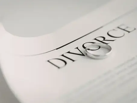 wedding ring on a divorce document illustrating the end of a marriage | LightingWay Therapy SG