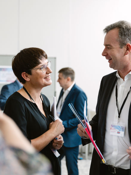 Frau und Mann die am Kongress teilnehmen unterhalten sich in der Pause