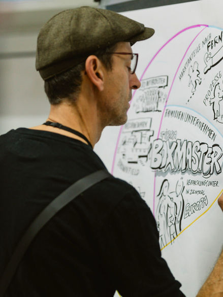 Mann skizziert Kongressinhalte auf Screen