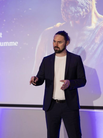 Mann hält Präsentation, Zitat von Aristoteles auf Bildschirm