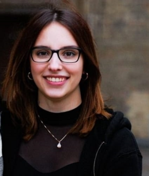 Porträt einer jungen Frau mit Brille und dunklem Oberteil, lächelnd in die Kamera – Gründerin der Assistenzagentur Remoaid