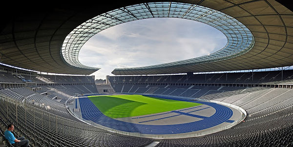 האצטדיון האולימפי של ברלין (Olympiastadion Berlin) הוא אחד מאתרי הספורט והתרבות המרכזיים של ברלין ושל גרמניה כולה. מדובר במבנה אייקוני המשלב היסטוריה מרתקת, אדריכלות מרשימה, ואירועים ספורטיביים ובידוריים מהמובילים בעולם. האצטדיון ממוקם בשכונת שארלוטנבורג שבמערב ברלין, והוא מוקף בפארק האולימפי (Olympiapark). בניית האצטדיון (1936): האצטדיון נבנה לקראת האולימפיאדה של 1936, שנערכה בברלין תחת שלטונו של אדולף היטלר. האולימפיאדה שימשה ככלי תעמולתי להצגת עוצמתה של גרמניה הנאצית לעולם. את האצטדיון תכנן האדריכל ורנר מארך, והוא נבנה בסגנון ניאו-קלאסי עם אלמנטים מרשימים ומונומנטליים שאפיינו את האדריכלות של התקופה. אירועים היסטוריים באצטדיון: במהלך אולימפיאדת 1936, האצטדיון היה עד לרגעים ספורטיביים משמעותיים, במיוחד לניצחונו של האצן האפרו-אמריקאי ג'סי אוונס, שזכה ב-4 מדליות זהב וסתר את רעיונות העליונות הגזעית של המשטר הנאצי. שימוש במלחמת העולם השנייה: בתקופת המלחמה, האצטדיון שימש למטרות צבאיות, ולאחר סיומה שימש את כוחות הברית ששלטו בעיר. שיפוץ ושדרוג (2004): לקראת אירוח משחקי גביע העולם