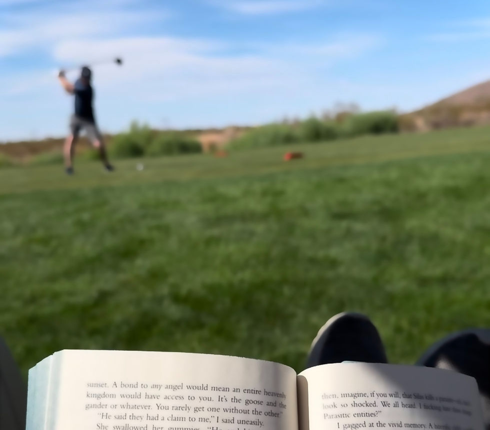 a person reading while a man is swinging a golf club on a grassy landscape in the background.