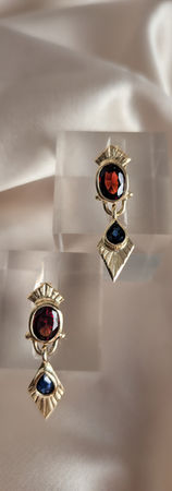Inspired by the geometry of Art Deco and reinterpreted through a more contemporary lens, the Isadora earrings combine blue sapphires and garnets in 12k yellow gold in a sculptural composition of colour, light and form.
