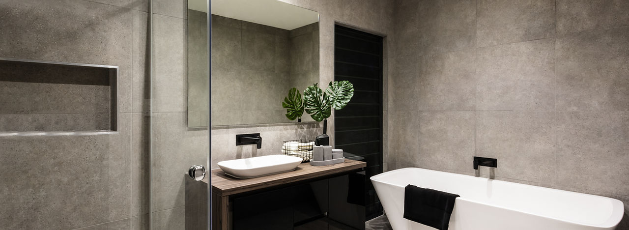Modern bathroom with a shower area and bath tub including a wall mirror beside a fancy pla