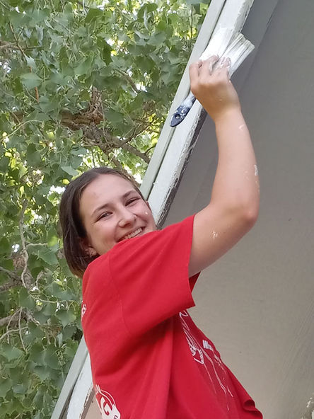 Student painting a house