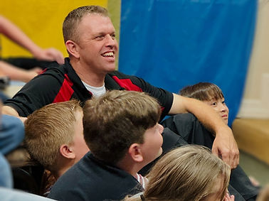 Image of Man and kids smiling during something funny