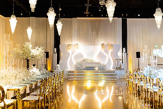 Wedding reception at Aristide McKinney with amber uplighting, moving head lights on stage and a monogram projected on the gold dance floor