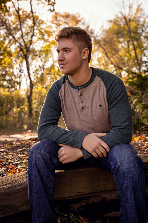 Boy sitting on log