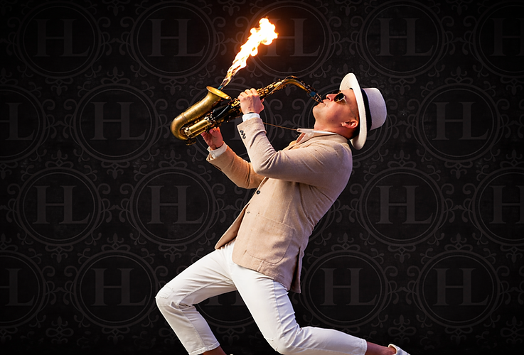 Fire sax performer playing saxophone with controlled flame effect at a live event