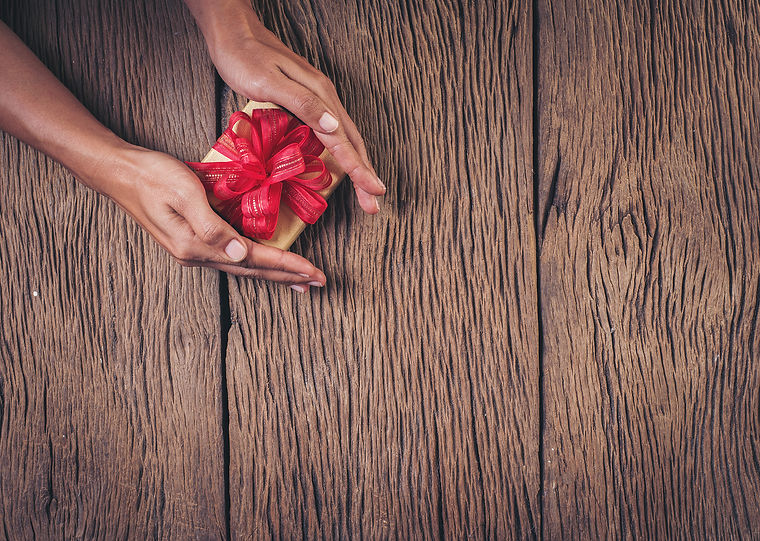 holding-gift-box-wood-background.jpg