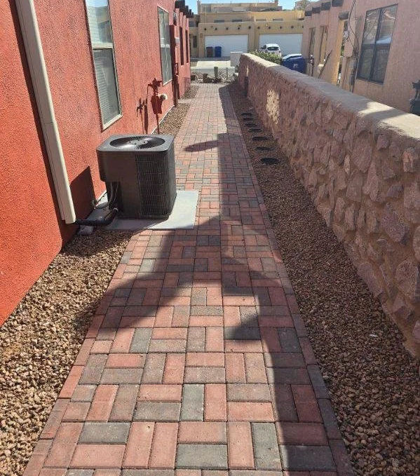 Side yard paver walkway with brick pattern design and gravel border installed by Garden Center in Las Cruces, New Mexico.