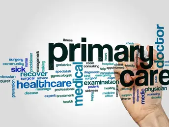 Hand writing words like "primary care," "healthcare," "medical" in different sizes and colors on a white background, conveying a focus on health.