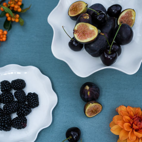 table with porcelain wave dishes and candleholder and fruit