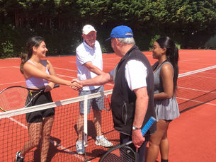 Walking Tennis session at Wickham Park with four walking tennis players smiling and shaking each others' hands over the net