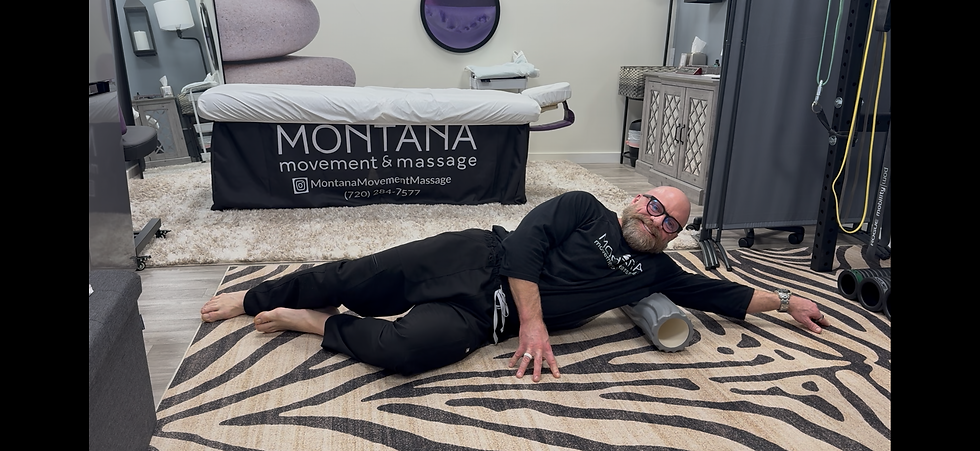 Shawn Person lying on their side foam rolling the armpit area targeting the teres minor muscle near the back of the shoulder.
