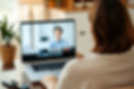 A woman at home in front of a laptop on a video call. Back view of her..jpg