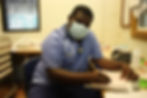 A doctor wearing a face mask doing some work at his desk