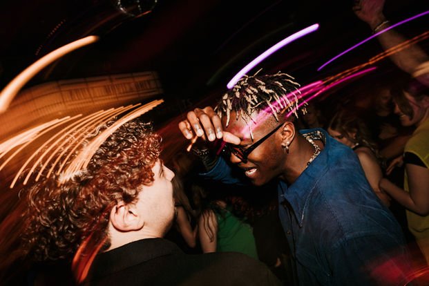 Tapahtumakuva yöelämästä, tanssia ja liikettä värikkäillä valoilla