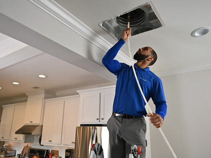 Certified technician performing professional air duct cleaning in a Coachella Valley home.