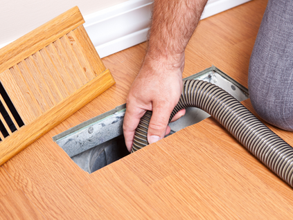Air duct cleaning technician at work in an Orange County home